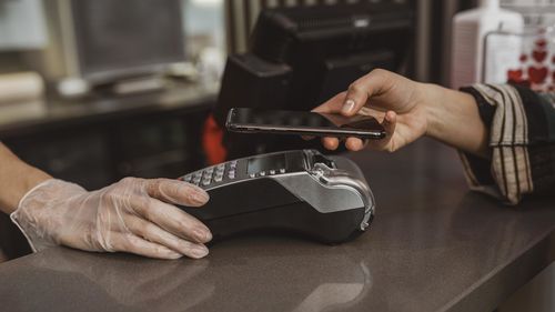 Cropped hand of woman paying at counter