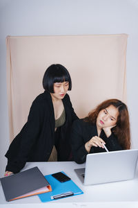 Young woman using smart phone on table