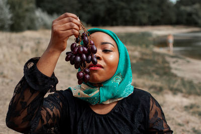 Young african woman eating grapes outdoor