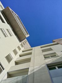 Low angle view of buildings against clear blue sky