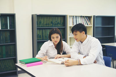 University students studying at table in library