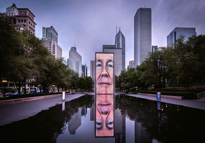 Reflection of buildings in lake against sky