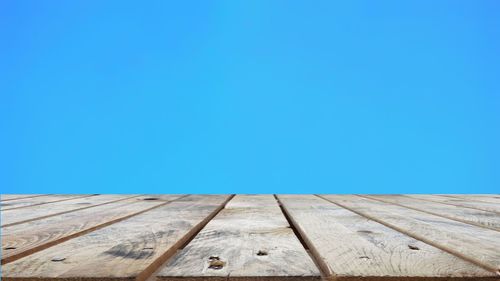 Low angle view of pier against clear blue sky