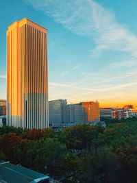 Modern buildings against sky during sunset in city