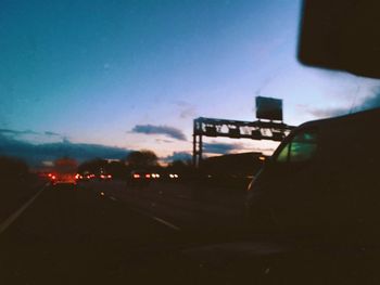 Close-up of car on road against sky during sunset