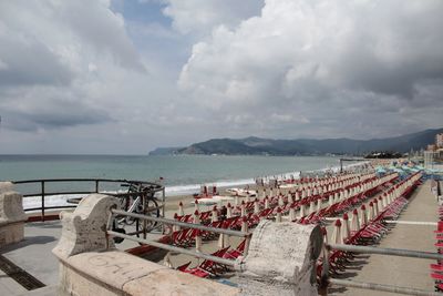 Chairs on beach against sky