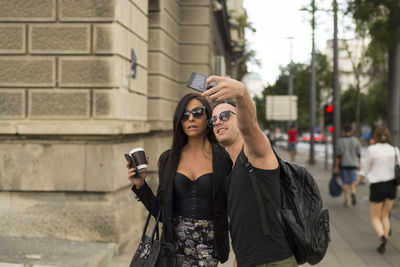 Man taking selfie with friend while standing on road