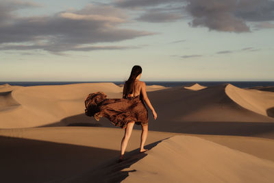 Rear view of woman walking on beach