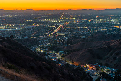 High angle view of illuminated cityscape against sky during sunset