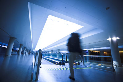 People walking in illuminated corridor