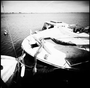 Boats moored in sea against sky