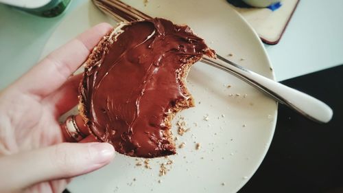 Cropped image of person holding bread with chocolate spread