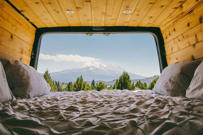 View of mount shasta from bed of camper van in oregon.