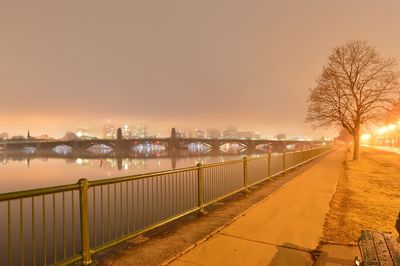 Bridge over river against sky during foggy weather