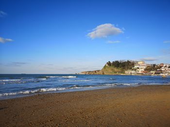 Scenic view of beach against blue sky