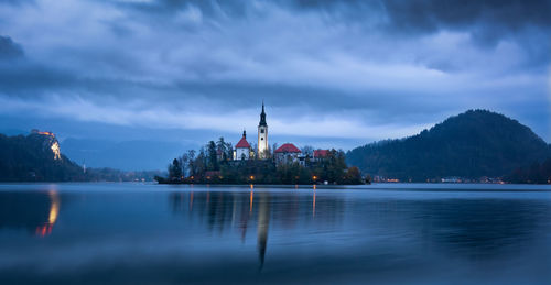 Dawn at lake bled in a cloudy day with island of the assumption of mary, mountains and bled castle