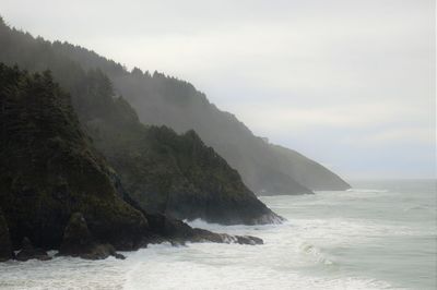 Scenic view of sea and mountains against sky