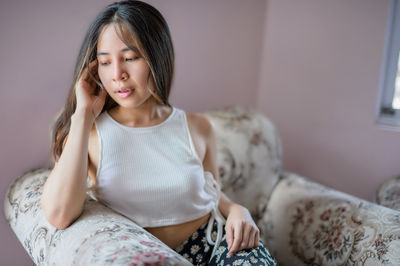 Portrait of young woman sitting at home