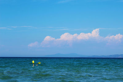 Low section of person with diving flippers swimming in sea