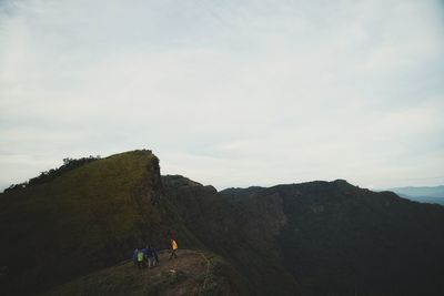 People walking on mountain against sky