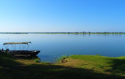 Scenic view of lake against clear blue sky