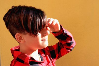 Portrait of boy holding red wall