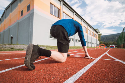 Detail of the body position of a professional athlete at the start of a 100m sprint