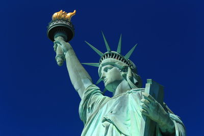 Low angle view of statue against blue sky