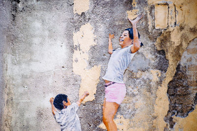 Man holding umbrella against wall