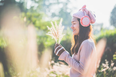 Smiling young woman wearing warm clothes outdoors