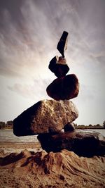 Stack of rock in water against sky