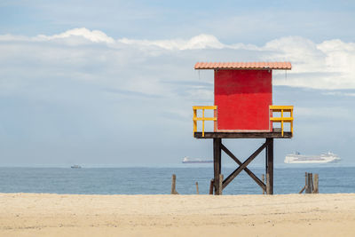 Lifeguard hut on beach against sky