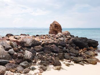 Rock formation on beach against sky