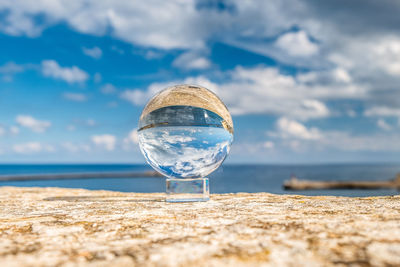 Crystal sphere against sky and sea