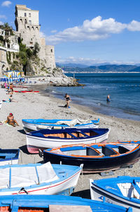 Boats in sea against cloudy sky