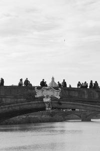 Statue by river against sky