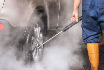 Midsection of man working on car