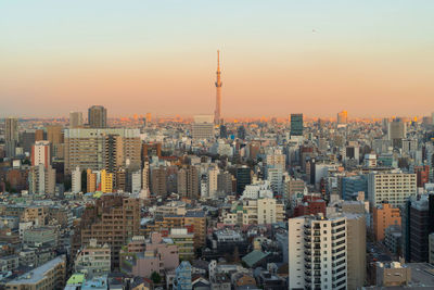 Aerial view of buildings in city at sunset