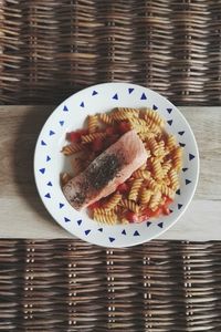 Directly above shot of pasta and salmon served in plate on table