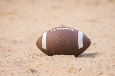Close-up of american football on sand