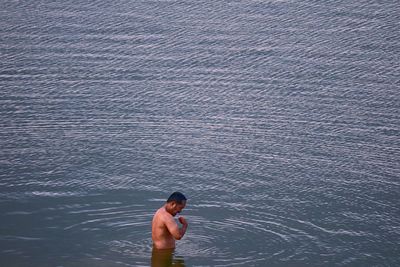 High angle view of shirtless man in sea