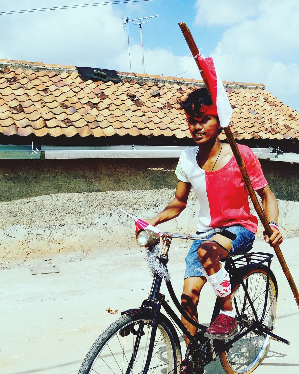 BOY RIDING BICYCLE AGAINST SKY