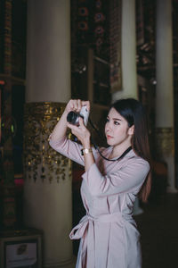 Young woman photographing at camera