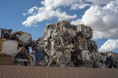 Stack of garbage on metal against sky