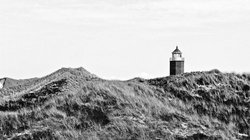 Lighthouse amidst buildings against sky