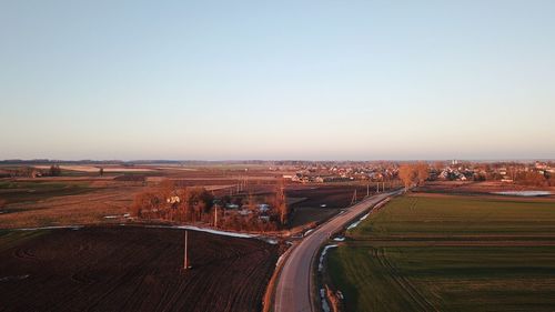 High angle view of road amidst field against clear sky
