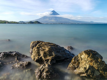 Scenic view of sea and mountains against sky