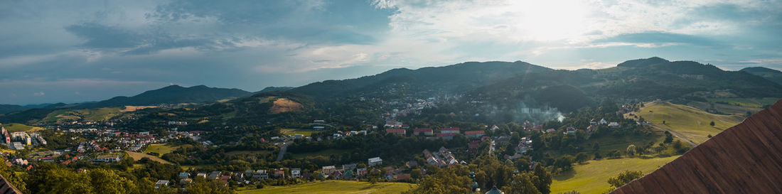 Panoramic view of townscape by mountains against sky