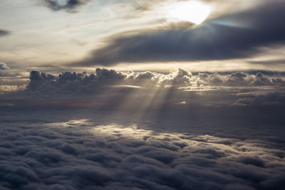 Sun shining through clouds seen from the sky