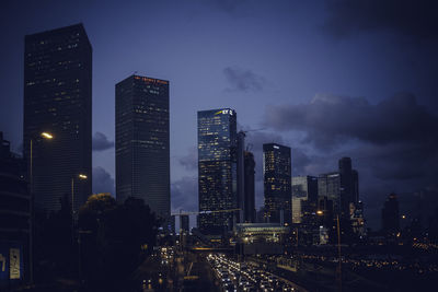 Illuminated buildings in city against sky at night